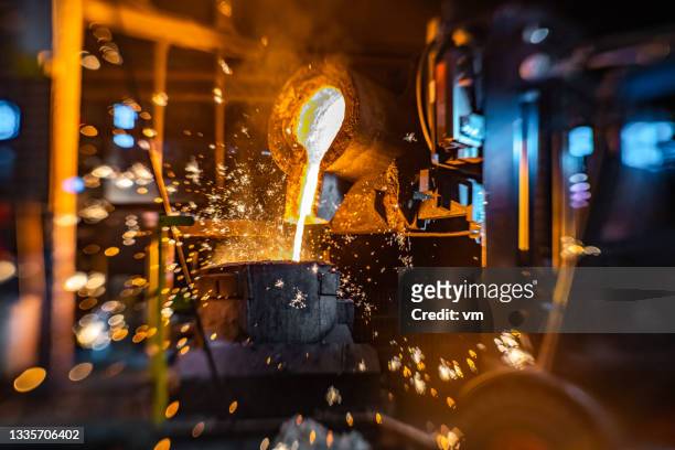 nahaufnahme der arbeiten mit flüssigem heißmetall in der gießerei - foundry stock-fotos und bilder