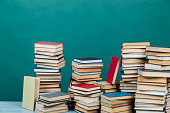 Stacks of books for teaching knowledge college library green background