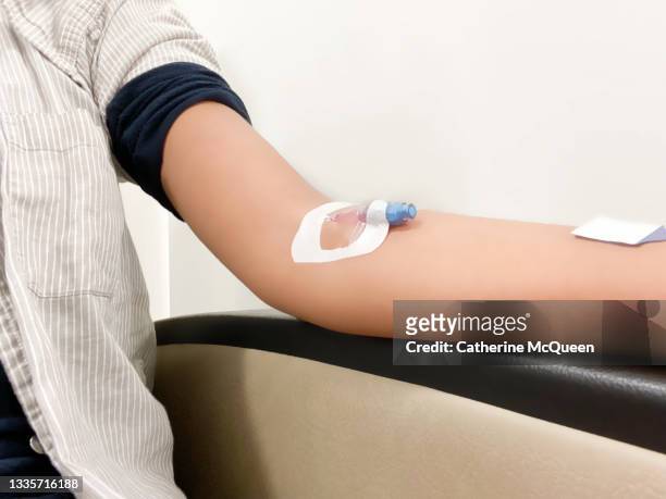 african-american woman sits in the emergency room with an intravenous port started - iv going into an arm stock pictures, royalty-free photos & images