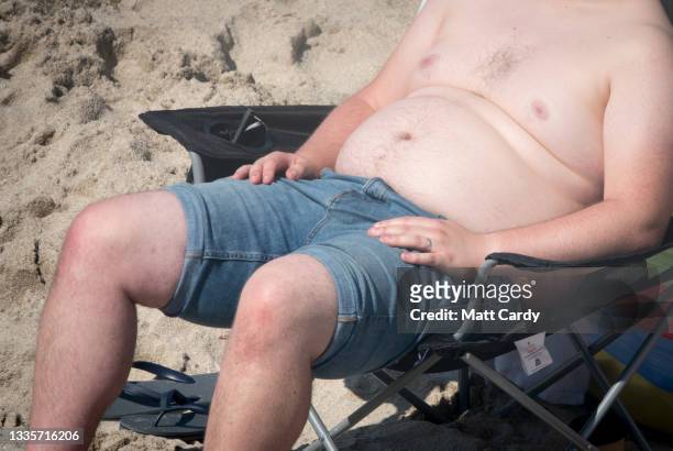 Man sleeps in a chair at Sennen Cove on August 13, 2021 near Penzance in Cornwall, England. The ongoing international travel restrictions due to the...
