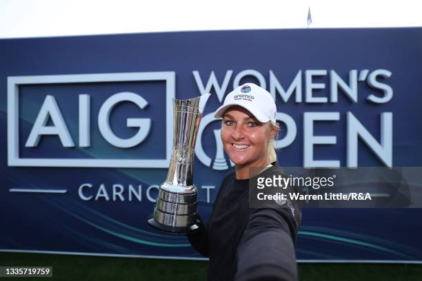 Champion, Anna Nordqvist of Sweden imitates a selfie as she poses with the AIG Women's Open trophy during Day Four of the AIG Women's Open at...