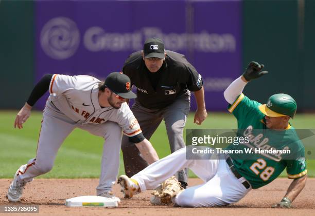 Matt Olson of the Oakland Athletics gets tagged out at second base by Kris Bryant of the San Francisco Giants in the bottom of the first inning at...