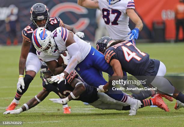 Tariq Thompson of the Buffalo Bills is dropped by Marqui Christian and Xavier Crawford of the Chicago Bears during a preseason game at Soldier Field...