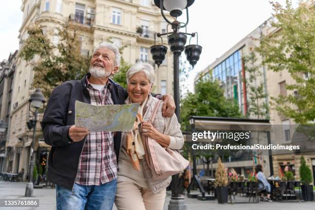 older travelers are sightseeing the city during a vacation using a city map. - travel map stock pictures, royalty-free photos & images