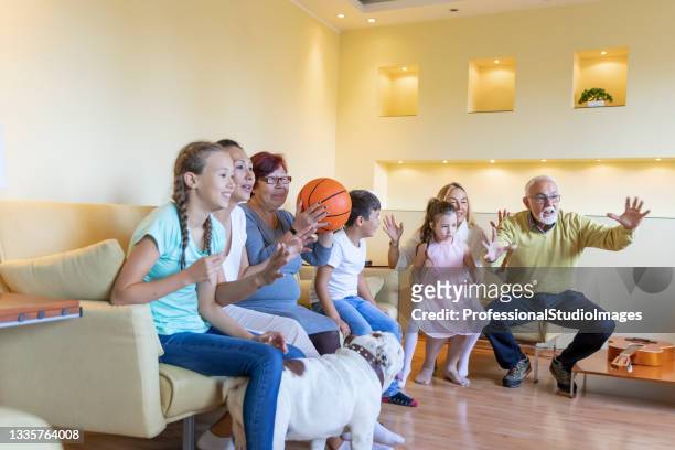 cheerful family supports national basketball team. - family tv pet stock pictures, royalty-free photos & images
