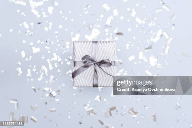 gift box wrapped in kraft paper and tied with gray ribbon and white blank on gray background decorated with confetti. top view, holiday concept. - box white flat imagens e fotografias de stock