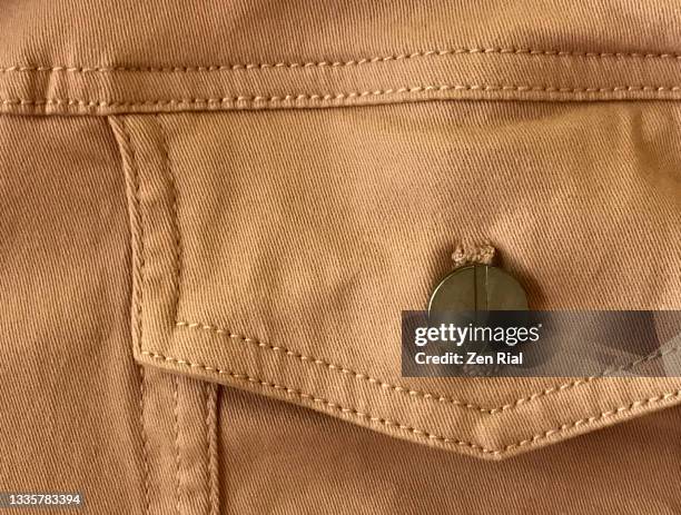 details on breast pocket and button of a light brown denim material in full frame - denim jacket stock pictures, royalty-free photos & images