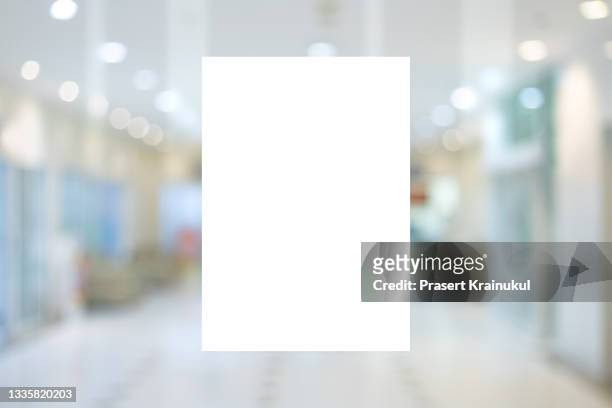 mockup a4 white paper or white promotion poster displayed on the front of bright office interior - placard stockfoto's en -beelden