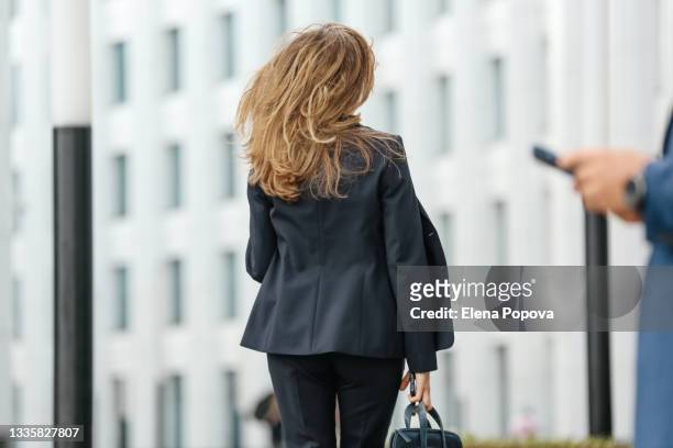 young adult business woman walking on the street with smartphone - russian business woman stock-fotos und bilder