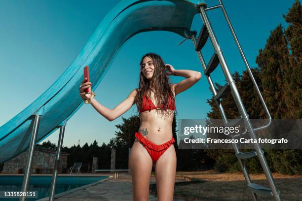 woman in red bikini does a selfie - body piercings 個照片及圖片檔