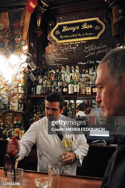 Waiter serves a client on November 17, 2011 in Paris, at the famous Harry's New York Bar, where the Bloody Mary, the Side Car and other cocktails...