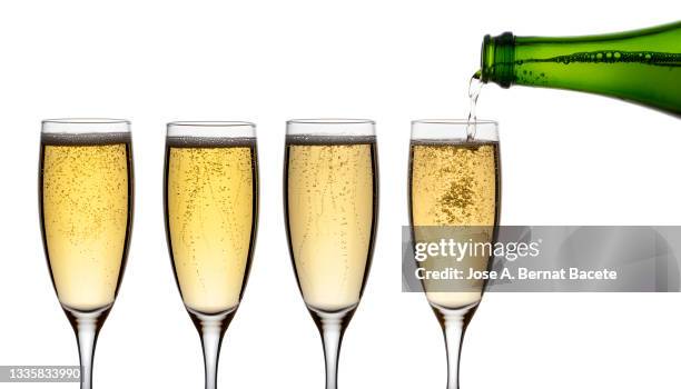 champagne bottle that fills 4 glasses on a white background. - champagnekleurig stockfoto's en -beelden