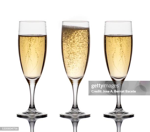 close-up of the bubbles in three glasses of champagne on a white background. - champagner gläser mit flasche unscharfer hintergrund stock-fotos und bilder