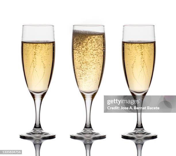 close-up of the bubbles in three glasses of champagne on a white background. - champagnekleurig stockfoto's en -beelden