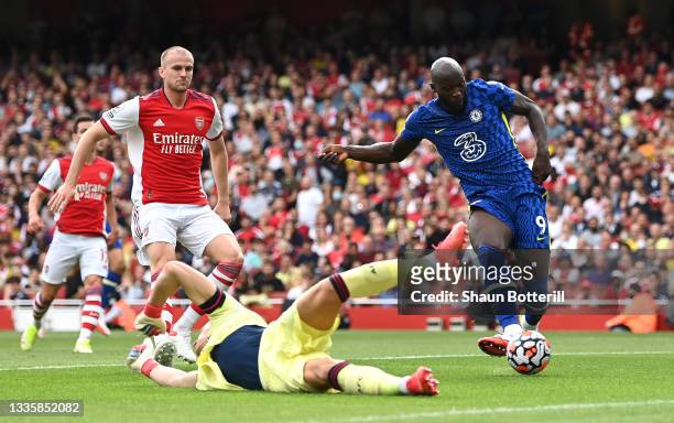 Romelu Lukaku of Chelsea shoots past Bernd Leno of Arsenal to score the first goal as Rob Holding looks on during the Premier League match between...