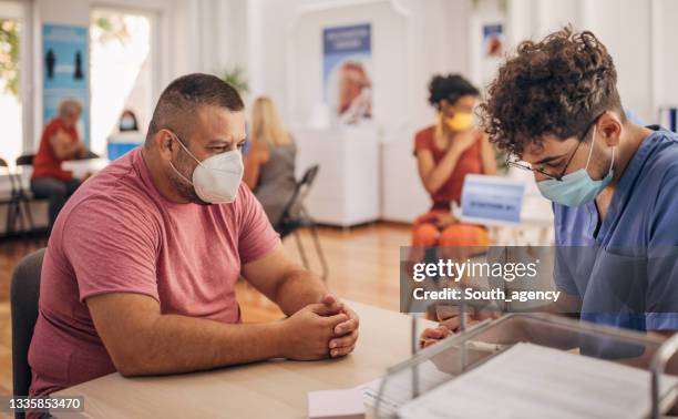 man in vaccination center - elderly receiving paperwork stock pictures, royalty-free photos & images