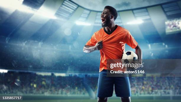 african -american football or soccer player at stadium in flashlights - motion, action, activity, competition concept - bola de futebol imagens e fotografias de stock