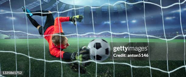 collage. male goalkeeper catching ball in jump at the stadium during sport match on dark sky background - redding sporten stockfoto's en -beelden