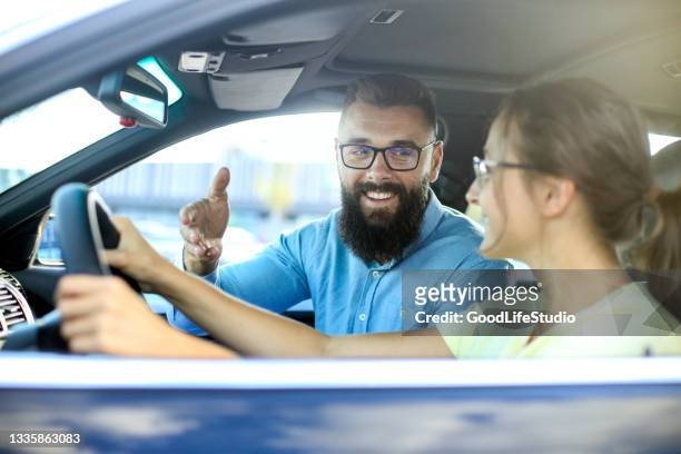 young woman learning how to drive a car - driving instructor stock pictures, royalty-free photos & images