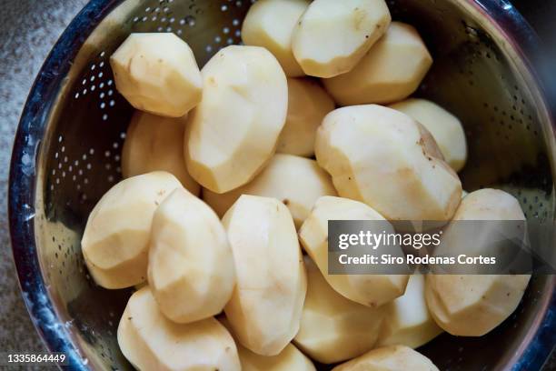 peeled potatoes on a bowl - geschält stock-fotos und bilder