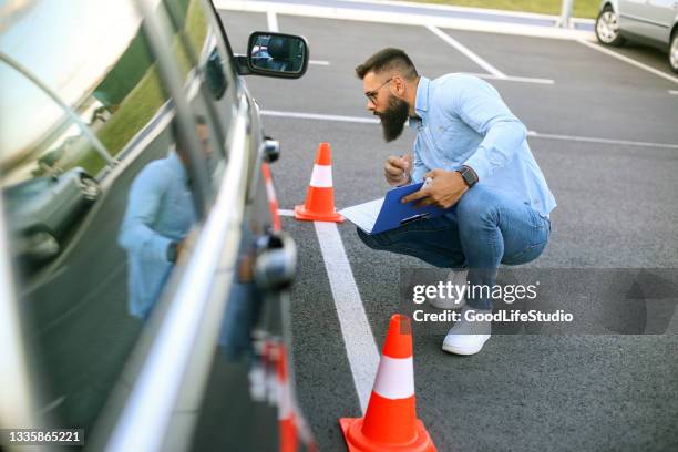 fahrlehrer prüft reifen vor einer prüfung - verkehrshütchen stock-fotos und bilder