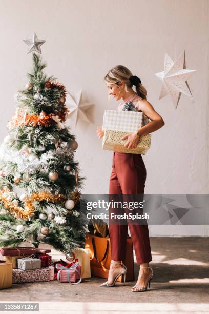 happy woman holding a christmas presents in her hands - woman ribbon happy stockfoto's en -beelden