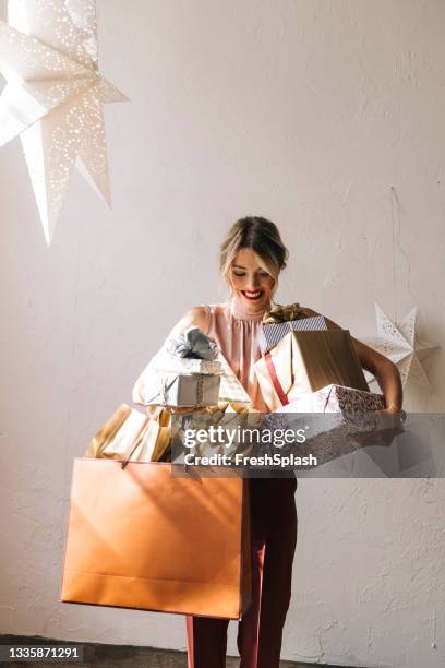 happy woman holding christmas presents in her hands - woman ribbon happy stockfoto's en -beelden