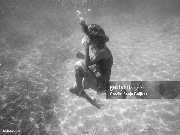 woman underwater - hugging knees stock pictures, royalty-free photos & images