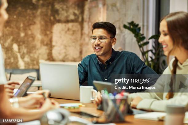 colleagues in meeting at coworking office - asian and indian ethnicities stock-fotos und bilder