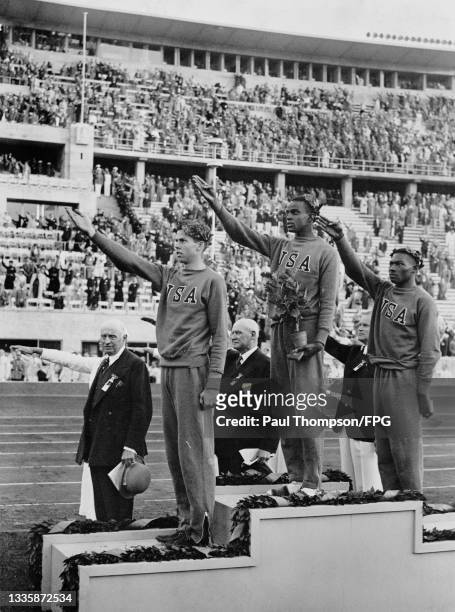 American athlete Delos Thurber , American athlete Cornelius Johnson , and American athlete Dave Albritton , each wearing a USA tracksuit and a laurel...