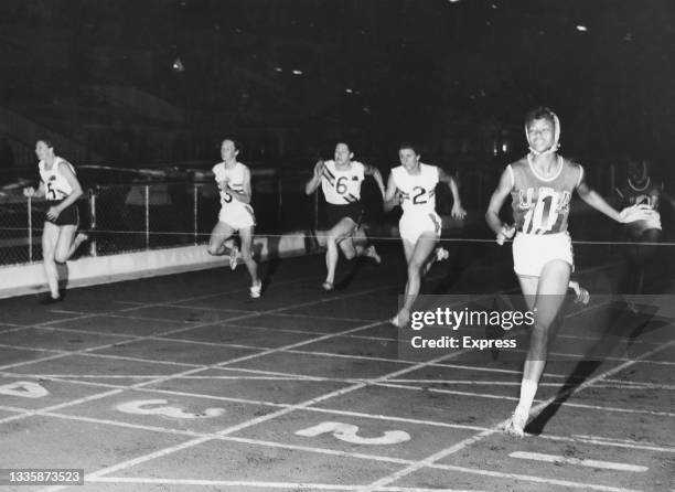 American athlete Wilma Rudolph crosses the finish line in first place in the 100-yards event, from Australian athlete Marlene Willard who finished...