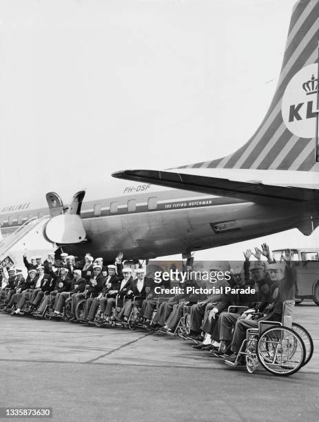Netherlands Paralympics team on the tarmac beside 'The Flying Dutchman', a Douglas DC-7 operated by KLM Royal Dutch Airlines, ahead of their journey...