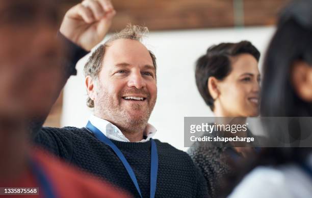 shot of a mature businessman raising his hand during a conference - employee feedback stock pictures, royalty-free photos & images