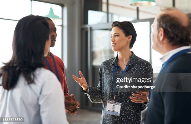 shot of a group of businesspeople networking at a conference - tradeshow stock pictures, royalty-free photos & images