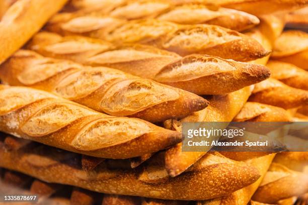 fresh baguettes for sale at the bakery, close-up view - flute stockfoto's en -beelden