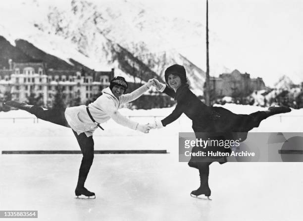 French figure skater Andree Joly and American figure skater Beatrix Loughran hold hands as they maintain a pose during a practice session at the...