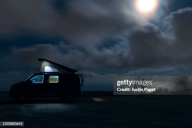 silhouette of campervan and couple looking at the view over the mediterranean sea - moonlight lovers fotografías e imágenes de stock