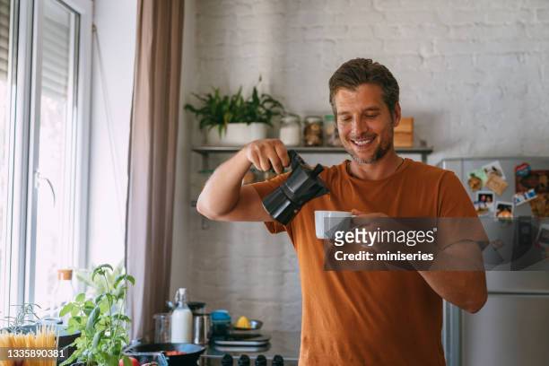cucinare a casa: bell'uomo con caffè in cucina - moka foto e immagini stock