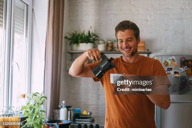 cozinhando em casa: homem bonito com coffe na cozinha - coffee maker - fotografias e filmes do acervo