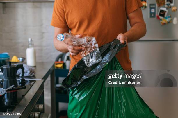 cucinare a casa: bell'uomo con sacchetto della spazzatura - packaging foto e immagini stock