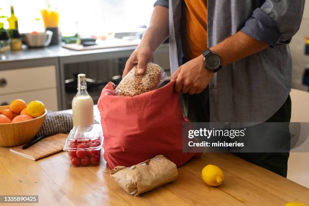 cooking at home: handsome man preparing to cook - canvas bag stock pictures, royalty-free photos & images