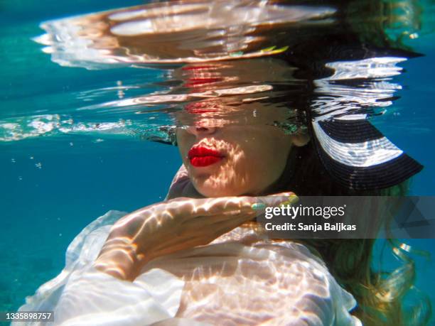 woman wearing hat undersea - underwater female models stock pictures, royalty-free photos & images