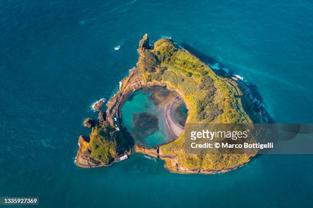small crater island with round lake, azores, portugal - volcanic crater stock-fotos und bilder