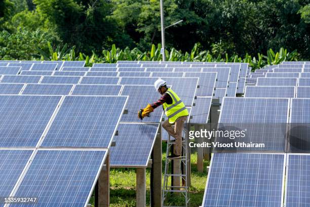 engineers checking and repairing solar panel at generating power of solar power plant. - solar power station stock-fotos und bilder