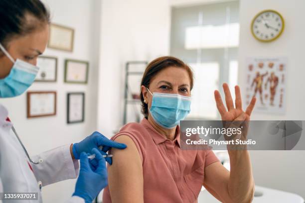 senior adult woman ottenere la sua quarta dose di una vaccinazione covid-19 - dose foto e immagini stock
