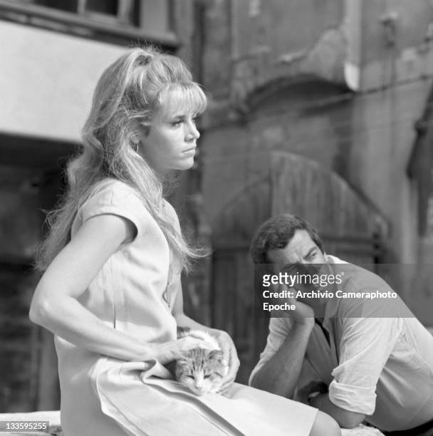 American actress Jane Fonda, caressing a cat, portrayed with Roger Vadim in the 'Remer' square, Venice, 1967.
