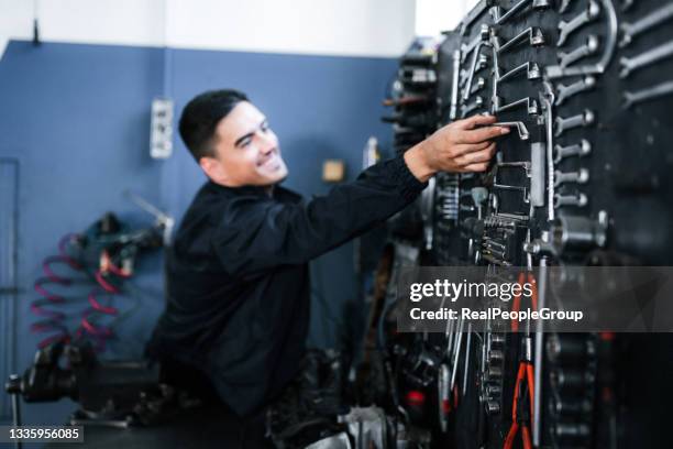 mechanic taking a tool from wall at the repair garage - car toolbox stock pictures, royalty-free photos & images