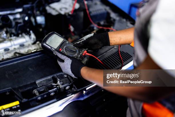 auto electrician troubleshooting a car engine - elektrische auto stockfoto's en -beelden