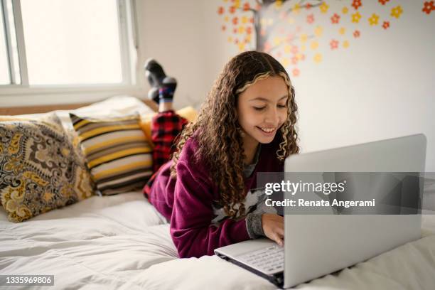 teen girl using laptop in bed. using social media or studying. - 10 years old girls stock pictures, royalty-free photos & images