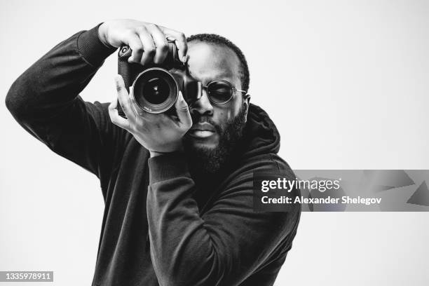 professional photographer at the studio, african american man wear black hoodie and sunglasses with digital camera is working. black and white concept photography - fitness photographers stock pictures, royalty-free photos & images